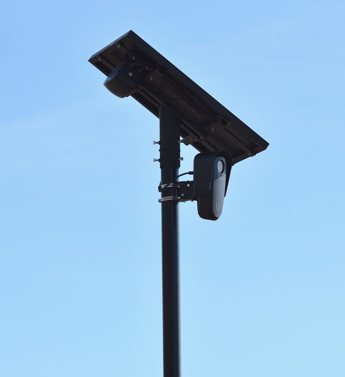 A solar-powered Flock Safety automated license plate reader mounted beside a roadway.